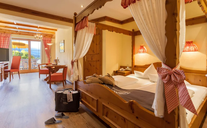 Cozy hotel room with wooden bed and balcony overlooking mountains