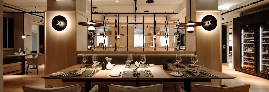 Modernes Restaurant mit gedeckten Tischen und warmem Licht