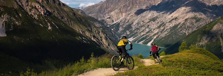 Mountain biking in Lombardy © Christoph Gramann Two mountain bikers riding on a trail with mountains and lake in the background