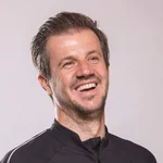 Mann mit Mountainbike-Urlaub-Shirt lächelnd vor neutralem Hintergrund