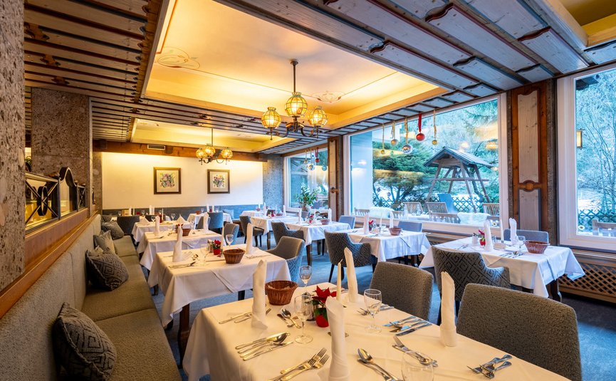 Feestelijk versierd restaurant met gedekte tafels en uitzicht op de winter