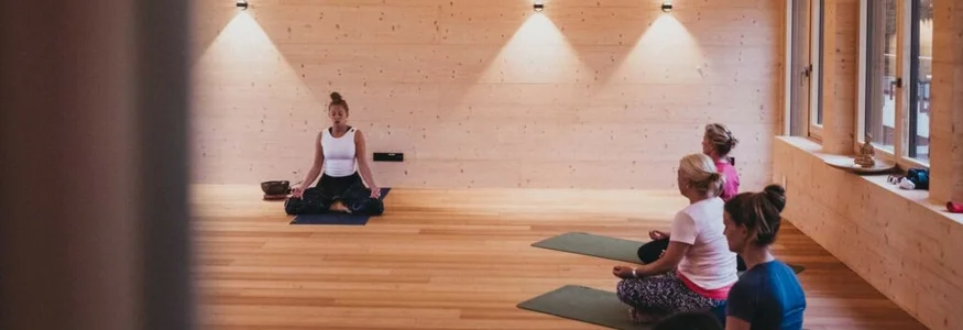 Yoga im Hotel Rupertus © Heldentheater Yoga-Kurs mit vier Personen in einem hellen, hölzernen Raum