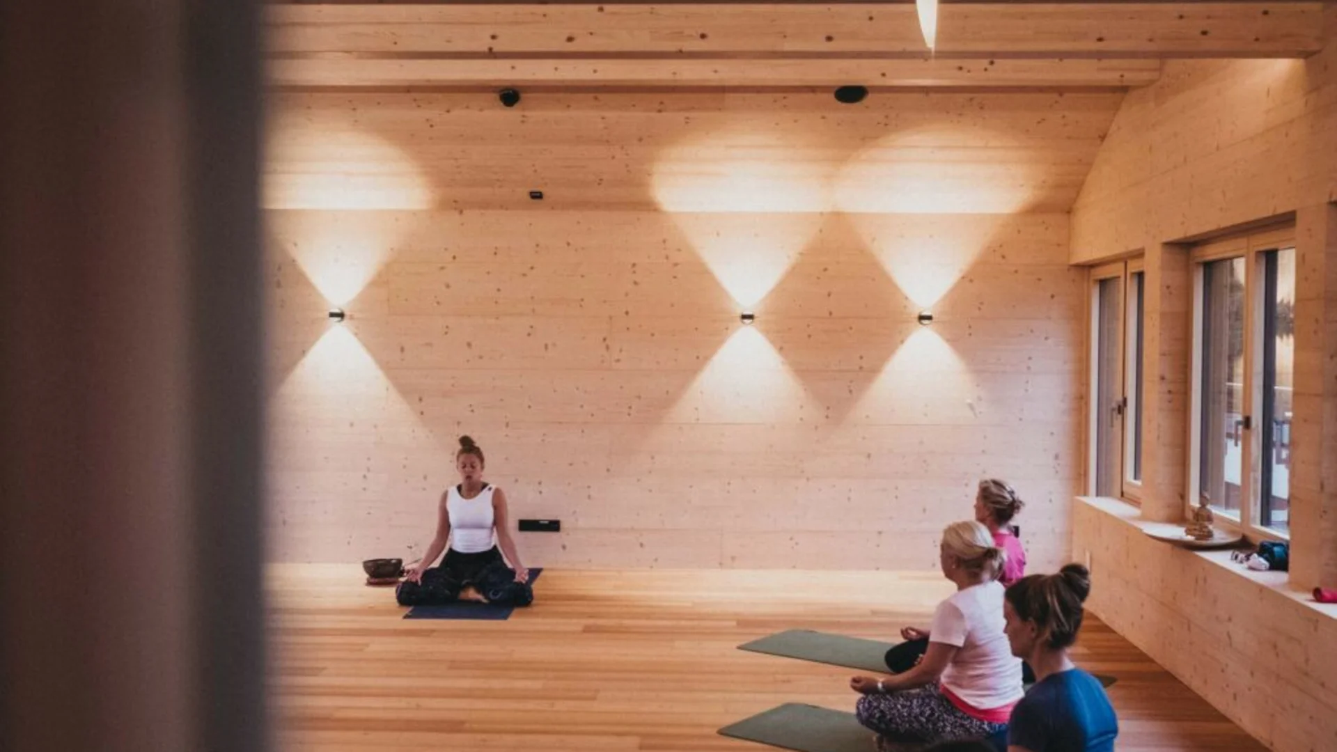 Yoga im Hotel Rupertus © Heldentheater - Yoga im Hotel Rupertus Yoga-Kurs mit vier Personen in einem hellen, hölzernen Raum