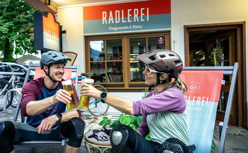 Bike Boutique Hotel Lindenhof **** Two cyclists clinking beer glasses outside Radlerei bistro