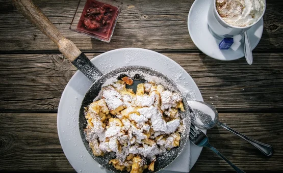 Kaiserschmarrn met poedersuiker, jam en koffie met slagroom