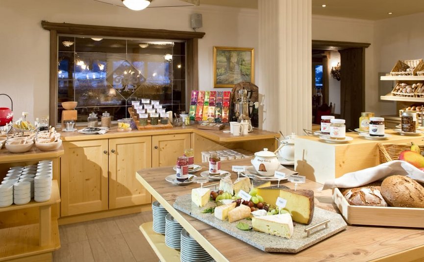 Breakfast buffet with cheese, bread, jam and cereal in cozy room