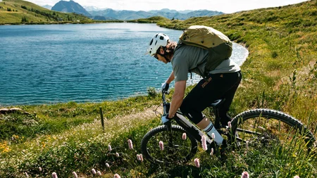 Mit Martina & Flo zum Mountainbiken im LifeSport Hotel Hechenmoos © Martina Wunderle / Flo Distl Mountainbiker mit Helm fährt an einem See in bergiger Landschaft vorbei