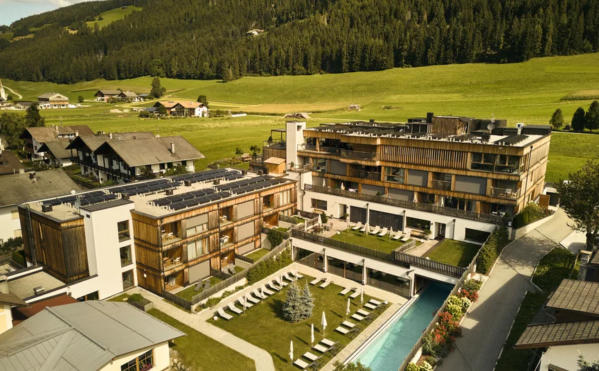 HIRBEN Naturlaub **** © David Rasche Hotel complex with pool and sun loungers in green mountain landscape