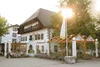 Traditionelles Gasthaus mit Blumendekor und Sonnenschein am Nachmittag