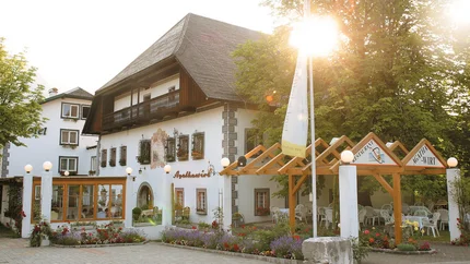 Traditionelles Gasthaus mit Blumendekor und Sonnenschein am Nachmittag