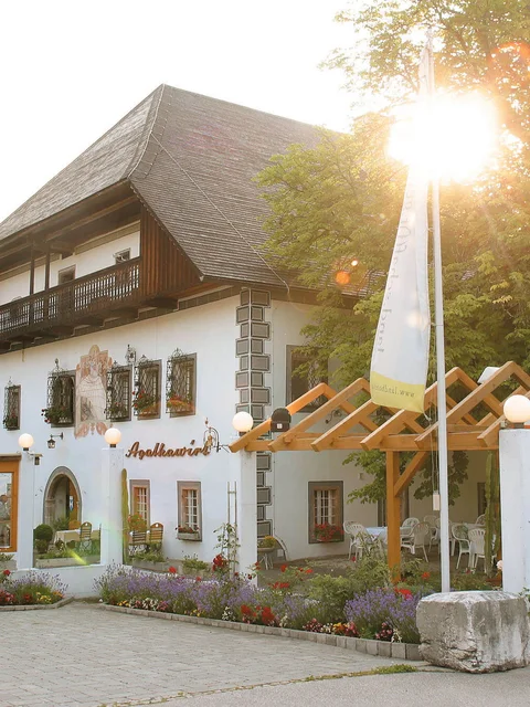 Traditionelles Gasthaus mit Blumendekor und Sonnenschein am Nachmittag
