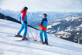 Ski & Wellness - 3 nights Two skiers in colorful outfits on snowy slope with mountain view