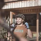 Fabian Stoll © Manuel Kottersteger Mann mit Fahrradhelm und Handschuhen lacht vor einem Hotel mit Holzeingang