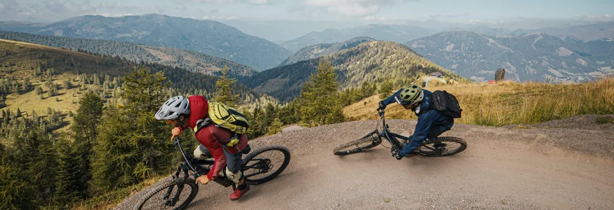 Two mountain bikers riding on a winding mountain trail