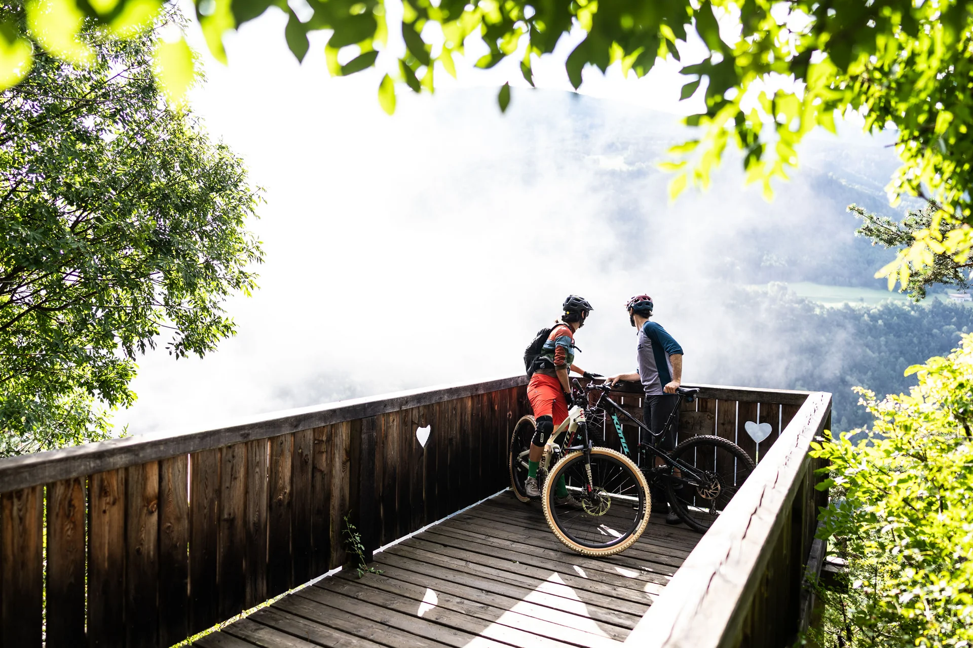 Mountain Bike Holidays © Gjis Ferkranus Zwei Mountainbiker auf einer Aussichtsplattform schauen ins neblige Tal