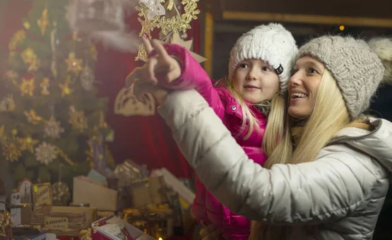 Vrouw en kind bekijken kerstversieringen 's nachts