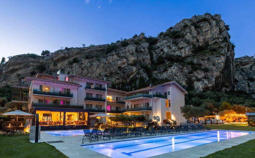 AktivHotel SantaLucia Gardasee **** © Fabio Staropoli Hotel mit beleuchtetem Pool am Abend vor einem großen Felsen