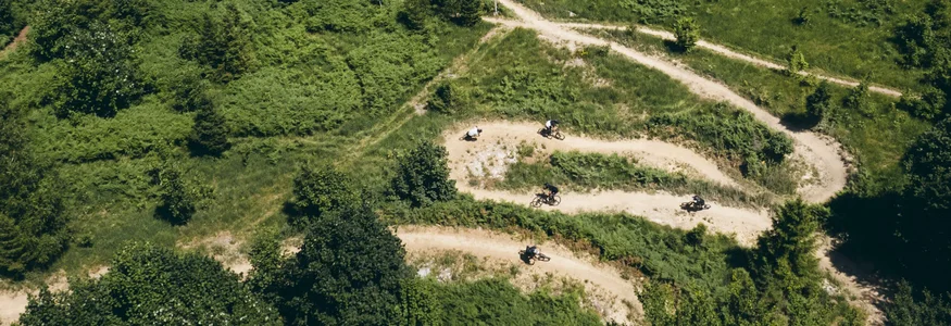 9 Gründe, warum Kočevsko noch ein echter MTB-Geheimtipp ist
© Klemen Humar - MTBTrailCenter Schmale kurvige Wege im Wald mit Mountainbikern auf einer Abfahrt