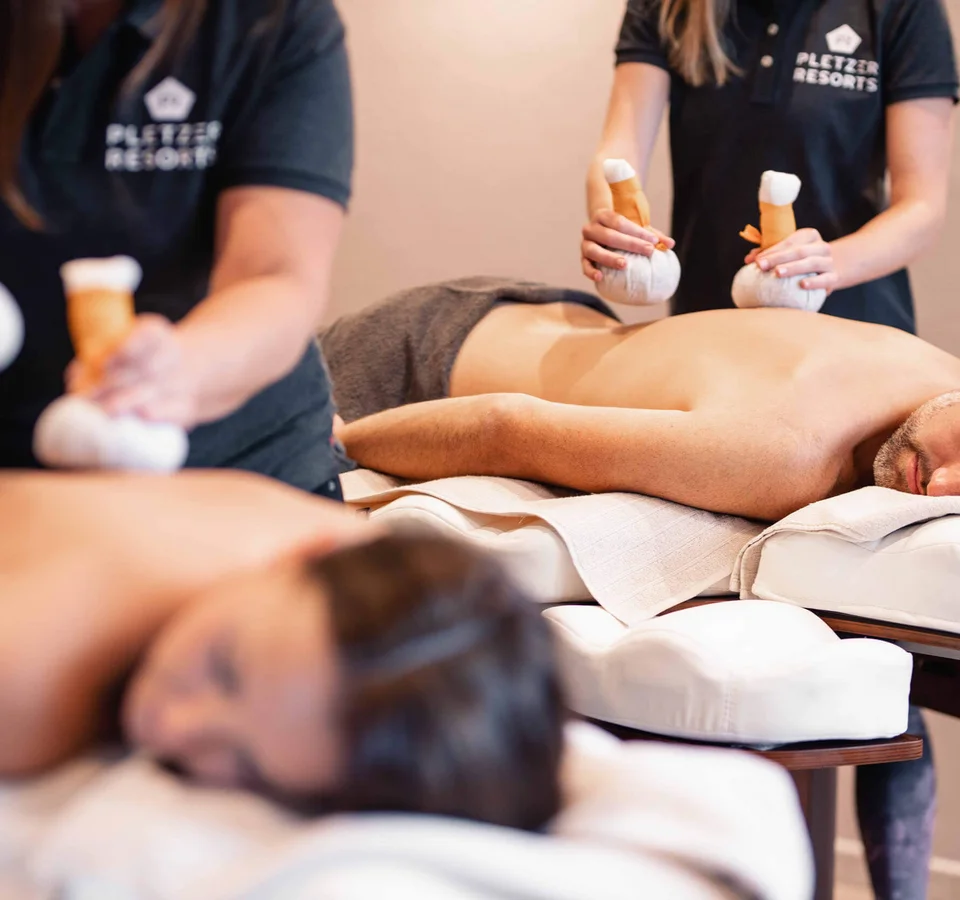 Good to know: 9 Wellness-Funfacts © Daniel Waschnig Zwei Personen erhalten Kräuterstempelmassagen in einem Spa
