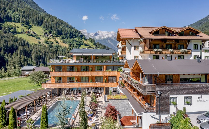 Hotel Weisses Lamm **** © Stephanie Maria Lohmann Modernes Hotel in den Bergen mit Außenpool und Terrasse bei sonnigem Wetter