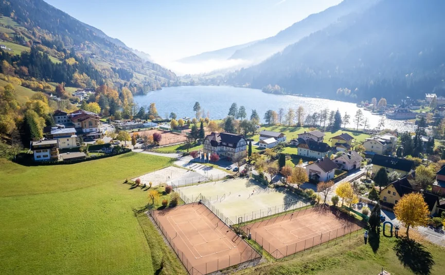 Family Herbst Auszeit 5=4 Bergmeer met dorp, beboste hellingen en tennisbanen op de voorgrond