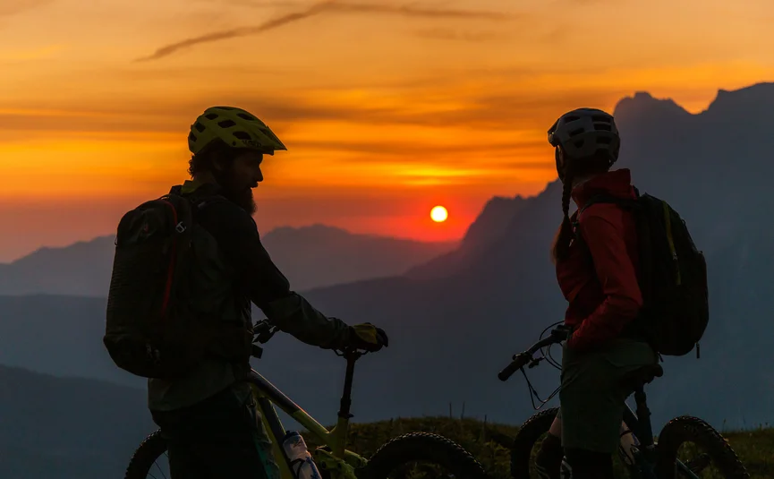 Zwei Mountainbiker genießen den Sonnenuntergang in den Bergen
