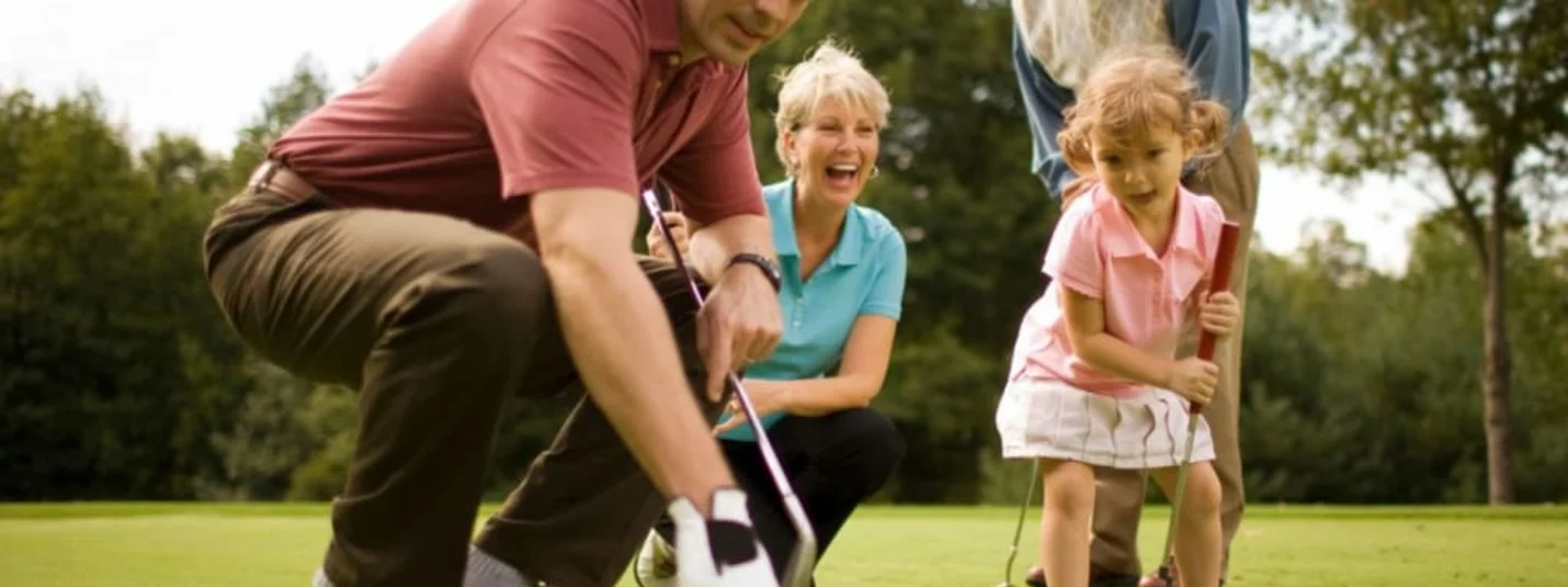 Familie spielt Golf auf dem Grün mit einem kleinen Mädchen und Großeltern