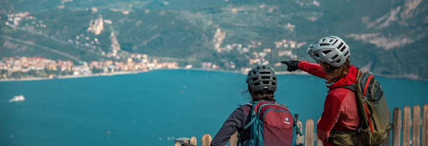 Nördlicher Gardasee © David Karg Zwei Radfahrer blicken auf einen See und Berge