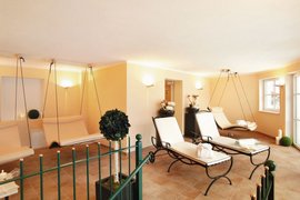 Lichte wellness lounge met moderne hangstoelen en ligstoelen