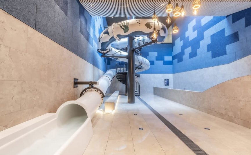 Modern water slide area with spiral slide in a blue and white room
