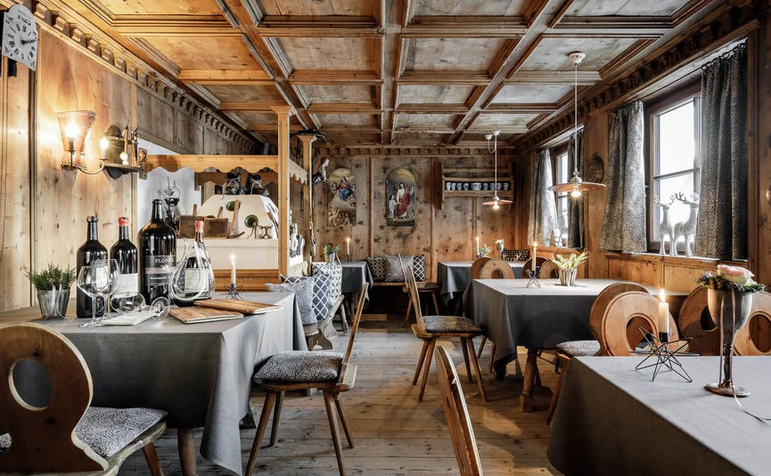 Rustikales Restaurant mit Holzmöbeln, Tischdecken und Weinflaschen