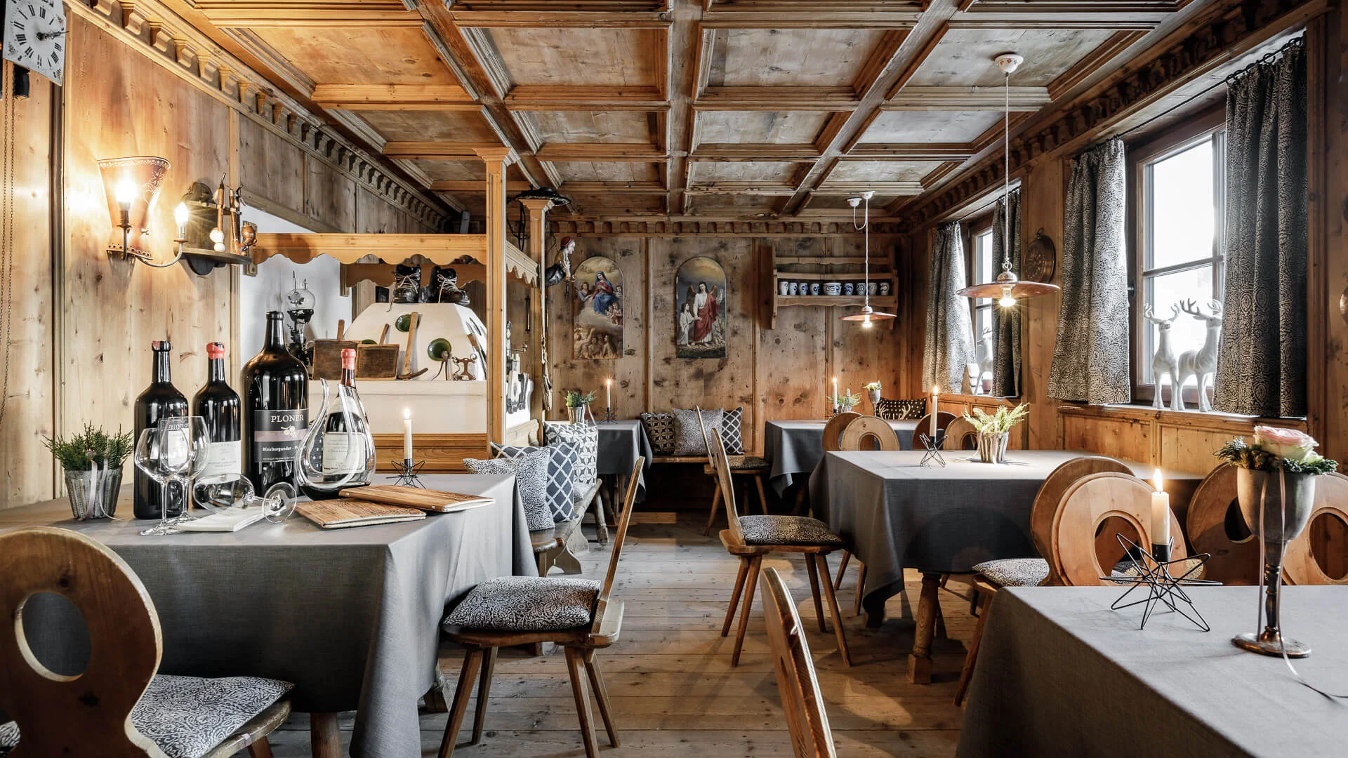 Rustikales Restaurant mit Holzmöbeln, Tischdecken und Weinflaschen