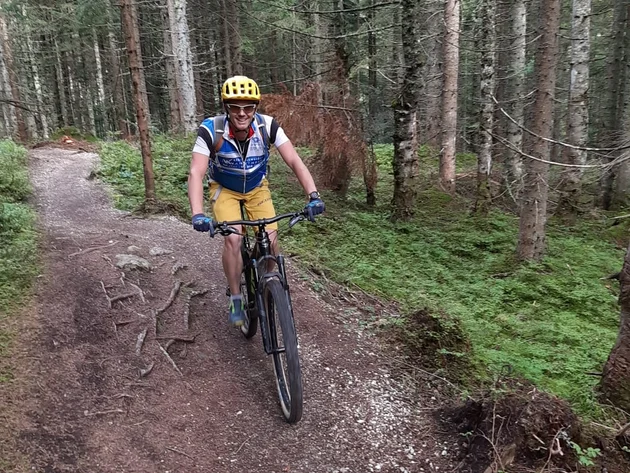 Mit Martina & Flo zum Mountainbiken im LifeSport Hotel Hechenmoos © Lifesporthotel Hechenmoos Mann fährt Mountainbike auf Waldweg mit grünen Bäumen