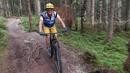 Mit Martina & Flo zum Mountainbiken im LifeSport Hotel Hechenmoos © Lifesporthotel Hechenmoos Mann fährt Mountainbike auf Waldweg mit grünen Bäumen