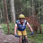 Mountainbike Urlaub in Tirol © Lifesporthotel Hechenmoos Mann fährt Mountainbike auf Waldweg mit grünen Bäumen