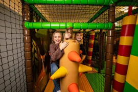Happy Family week Two children playing in a colorful indoor playground