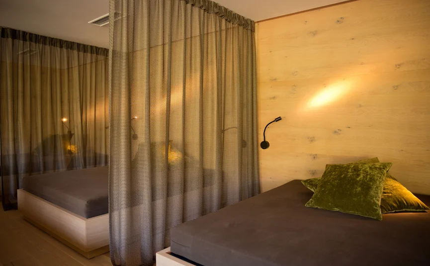 Modernes Schlafzimmer mit zwei Betten und durchsichtigen Vorhängen