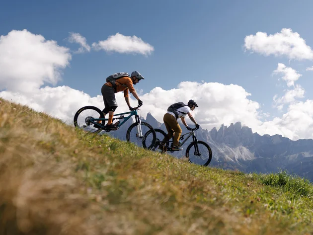 Das war die bike festa Südtirol in Brixen © Brixen Tourismus - Biken auf der Plose Zwei Mountainbiker fahren über einen grasbewachsenen Hang vor einer alpinen Bergkulisse