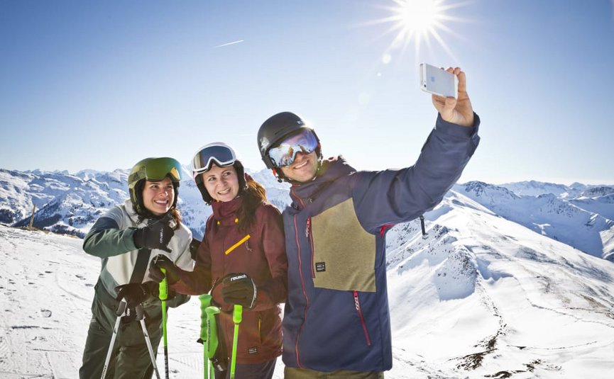 SKI OPENING Drie skiërs maken een selfie op besneeuwde berg bij zonnig weer