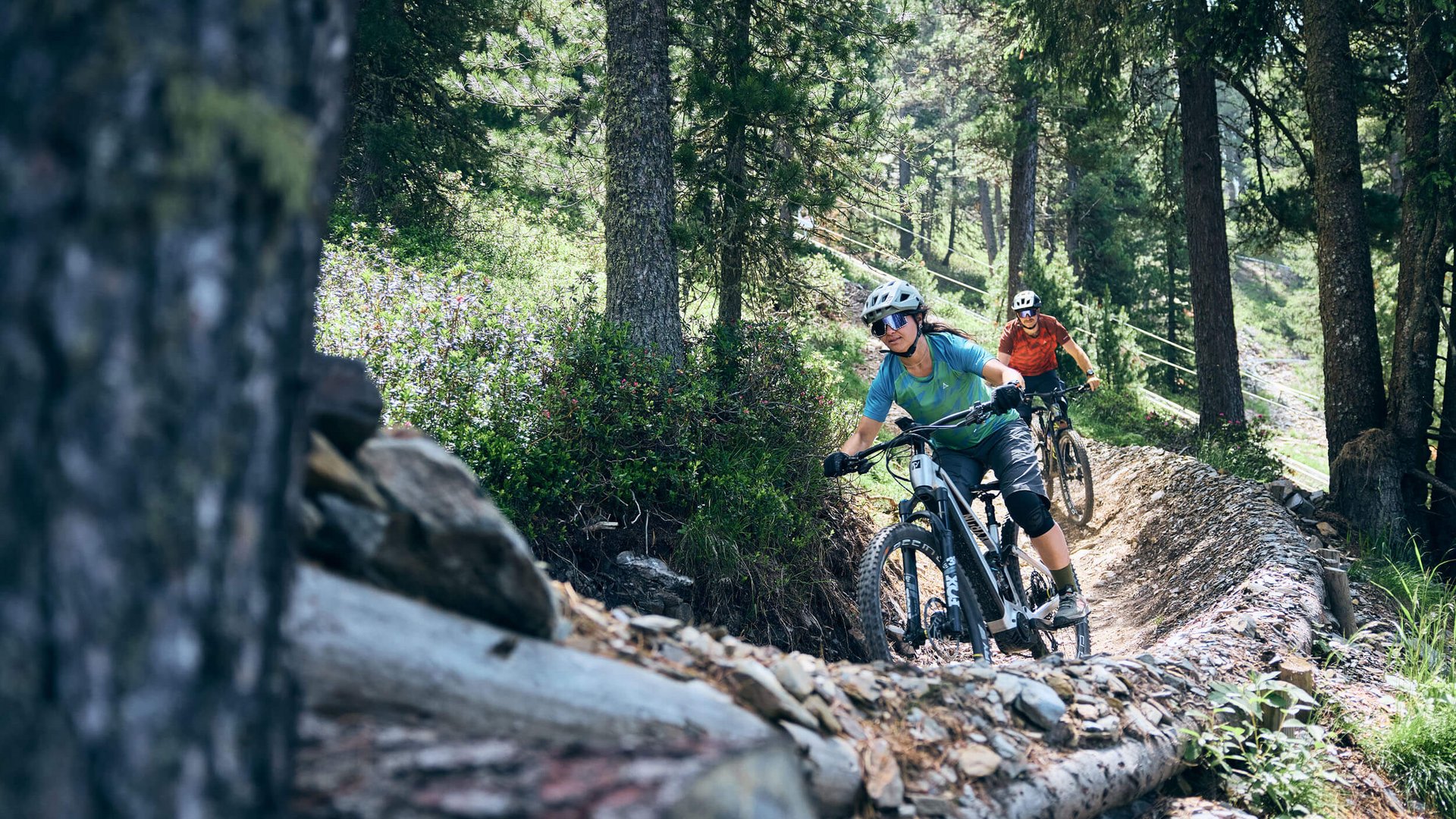 Zwei Mountainbiker fahren auf einem kurvigen Waldpfad