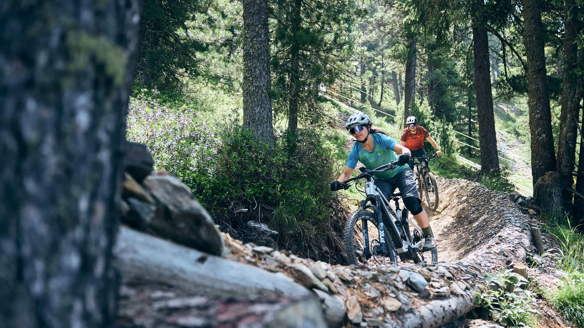Zwei Mountainbiker fahren auf einem kurvigen Waldpfad