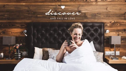 Frau lächelnd im Bett mit Tasse und Schriftzug entdecken und verlieben