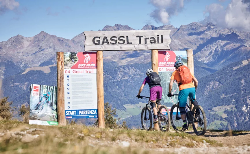 Zwei Mountainbiker starten auf dem Gassl Trail vor Berglandschaft