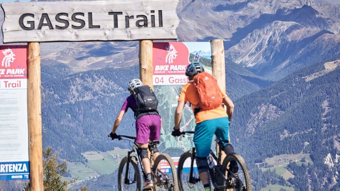 Zwei Mountainbiker starten auf dem Gassl Trail vor Berglandschaft