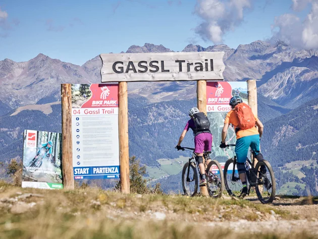 Zwei Mountainbiker starten auf dem Gassl Trail vor Berglandschaft