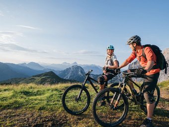 Zwei Mountainbiker machen Pause in den Bergen bei Sonnenuntergang