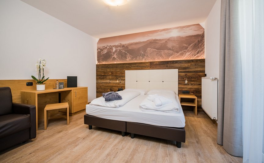 Moderne slaapkamer met tweepersoonsbed, bureau en bergwanddecoratie