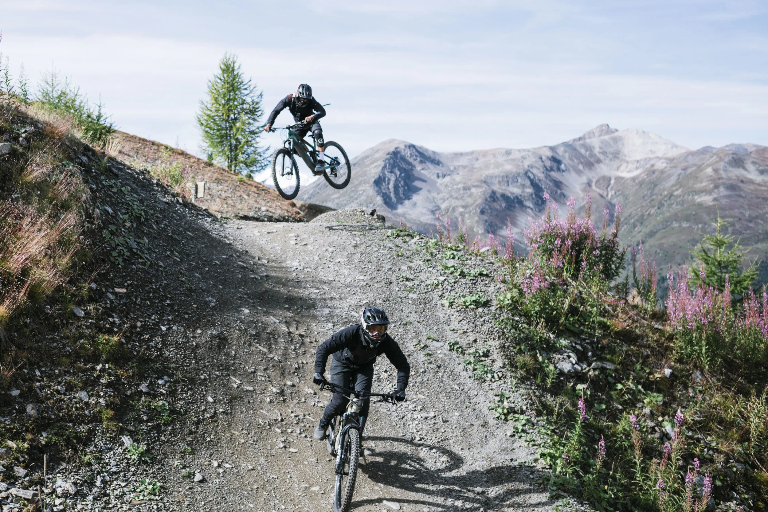 Zwei Mountainbiker auf einem steinigen Bergtrail in den Alpen