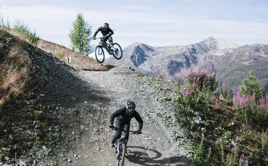 Zwei Mountainbiker auf einem steinigen Bergtrail in den Alpen