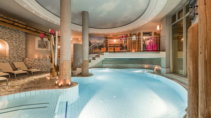 Indoor pool with candles and relaxing lounge chairs